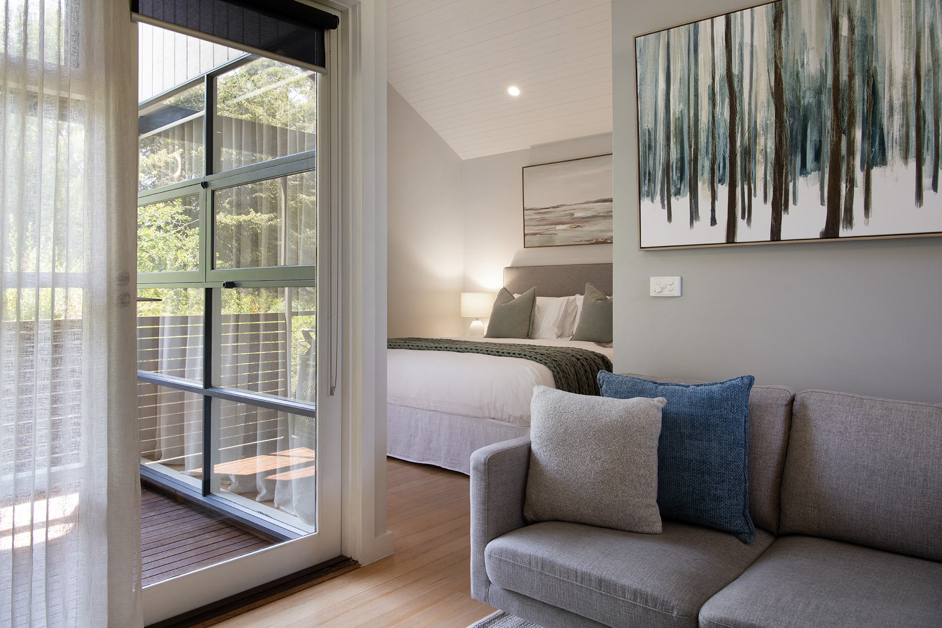 Balneo's light-filled living room and king bedroom overlooking the trees